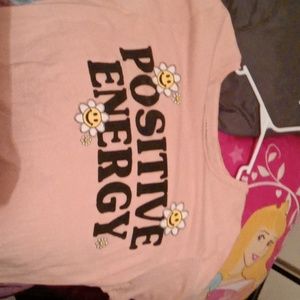 A pink shirt that says stay positive on it with little sun flowers
